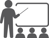 Icon of a teacher pointing at a chalkboard to represent training