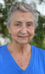 Woman with short gray hair wearing a light blue shirt