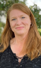 Woman with red hair wearing a black shirt